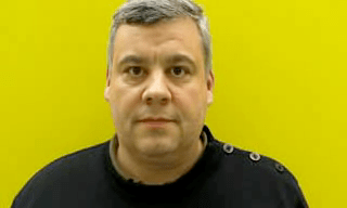 Ein einzelnes Frame des Videoelements. Es ist eine Person in einem schwarzen T-Shirt zu sehen. Die Hintergrundfarbe ist gelb.